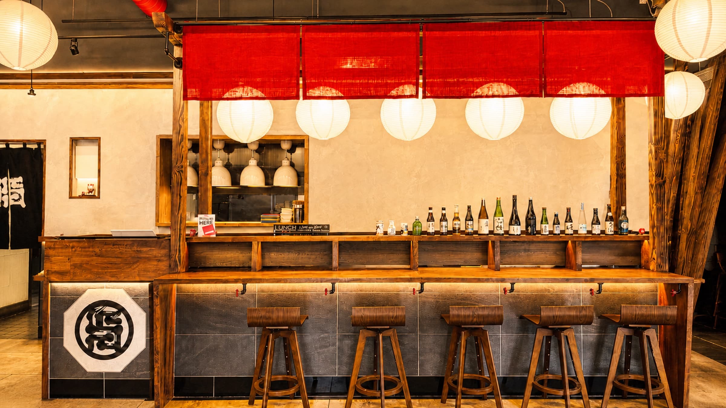 The Akatora ramen bar with red noren and a curated row of sake bottles