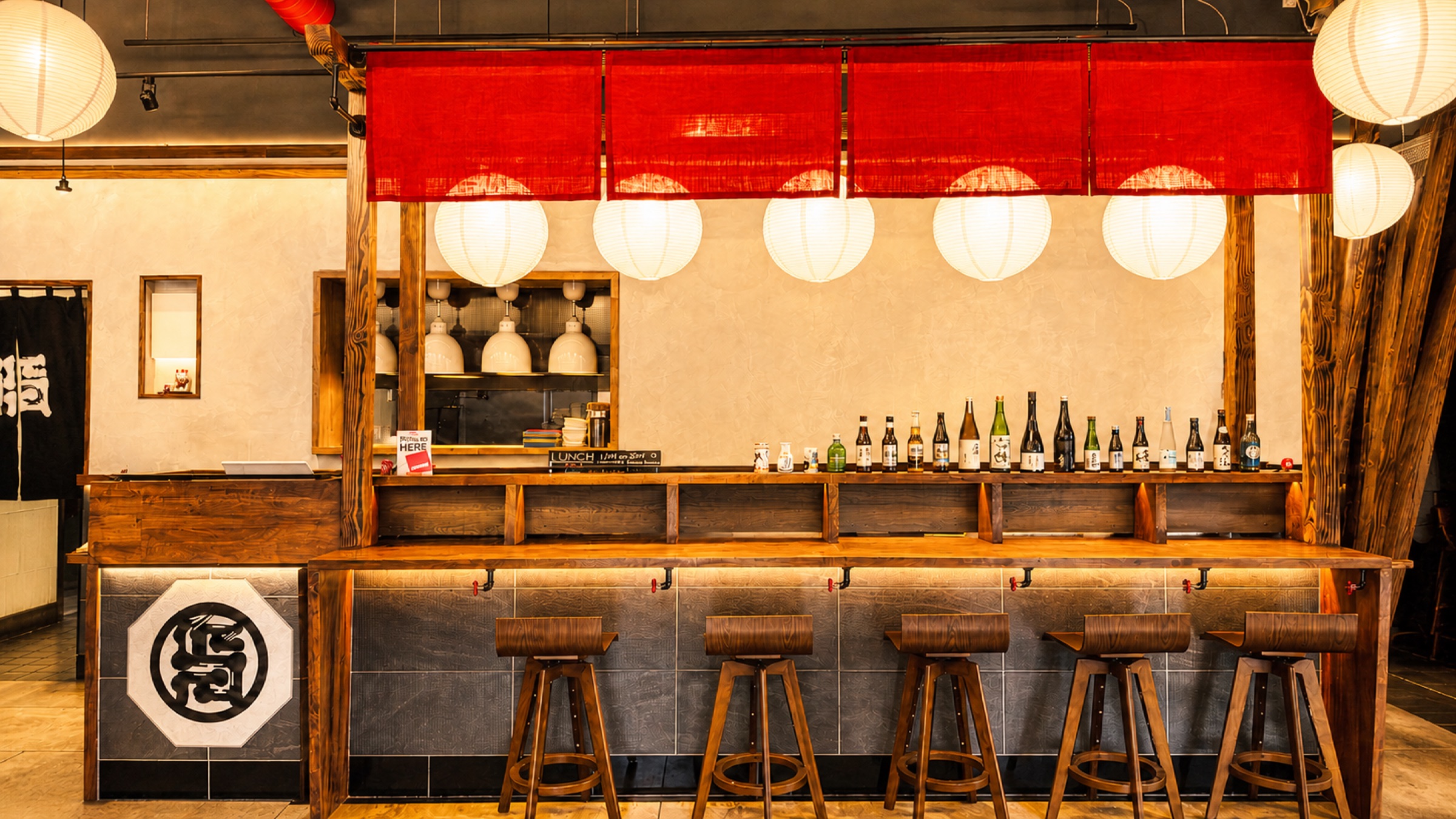 The Akatora ramen bar with red noren and a curated row of sake bottles